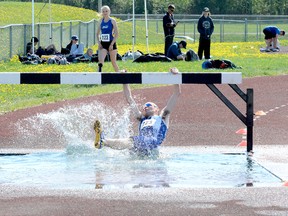 Connor Stewart, of Timmins High & Vocational School, reaches up in an attempt to grab onto the jump as he slides into the water hazard during the opening lap of the Open Boys 2,000-metre steeplechase event at the 2018 NEOAA Track & Field Championships at Timmins Regional Athletics and Soccer Complex on Wednesday. Stewart managed to overcome the setback and finished in third place.  THOMAS PERRY/THE DAILY PRESS