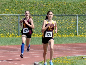 Maxine Dupuis, of École secondaire catholique Thériault, leads teammate Jordyn Bartolomucci around the bend during the 1,500 metres at the 2018 NEOAA Track & Field Championships at Timmins Regional Athletics and Soccer Complex on Wednesday. Due to the low number of entries, Midget, Junior and Senior Girls were all combined in the same event. Dupuis went on to win the Senior Girls title, while Bartolomucci captured the Midget Girls crown.  THOMAS PERRY/THE DAILY PRESS