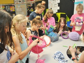 McNaughton Avenue Public School students Ava Parry, Eva Phair, Blair Saunders, Jordyn Butcher, Catherina Picard, Sadie Hamilton, Hannah Babb-Wagner, Hallie Polkinghorne and Aeowyn Dunlop knit hats for babies born at the Chatham-Kent Health Alliance during their knitting club at the Chatham school May 30. Tom Morrison/Chatham This Week