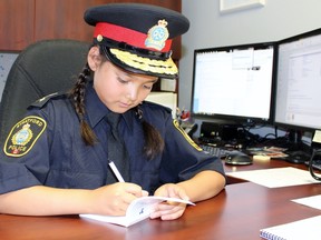 Leah Russell, 9, makes notes while sitting at the Stratford police chief’s desk during her Chief for a Day experience on Friday, June 1, 2018 in Stratford, Ont. (Terry Bridge/Stratford Beacon Herald)