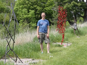 Stefan Duerst stands with some of the sculptures at his Godfrey Sculpture Park
