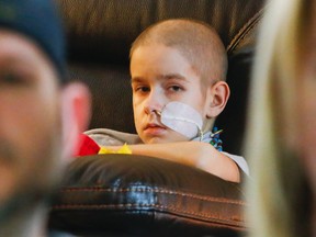 Luke Hendry/The Intelligencer
Aidan Reil, 11, sits on the couch at home in Trenton, Thursday, May 31, with his parents, Wayne Reil and Sarah Grover, nearby. He has inoperable brain cancer and his parents are among those urging the Canadian government to improve access for children with cancer to clinical trials.