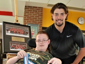 Dillon Anderson holds Colton Point's World Junior hockey gold medal with his Team Canada photos at the top left during a community thank you event held at Chippewa Secondary School, Saturday. Dave Dale, The Nugget