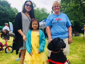 Lili Vilaysone, with daughter Ava Mina, and Vicky Spadoni of Autism Dog Services with service dog Matrix at the Ingersoll Safe Cycling Family Bike Day.The event hoped to raise $8,000 for an autistism service dog for Ava. HEATHER RIVERS/SENTINEL-REVIEW