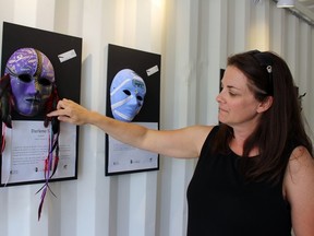 Sam Pocock points to one of the masks in the Unmasking Brain Injury Project inside the Steelbox Art Lab on Friday, June 1, 2018 in Stratford, Ont. Terry Bridge/Stratford Beacon Herald/Postmedia Network