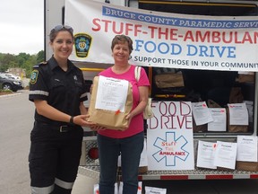 Paramedic Jennifer Rankin (left), with the Bruce County Paramedic Services, received donated groceries from Sylvia Deakins, of Georgian Bluffs, at the Stuff-the-Ambulance food drive at Foodland in Wiarton, June 1. Photo by Anastasia Graham