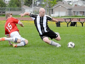 Matt Maguire, of Timmins United Football Club, slides into a kick while avoiding an attempted tackle from Jimmy Cote, of the Kapuskasing Longhorns, during the first half of a TMSL game the Timmins Regional Athletics and Soccer Complex on Sunday. Timmins United jumped out to a 2-0 first-half advantage and went on to defeat the Longhorns 4-1— with Cote notching the lone Kapuskasing goal.  THOMAS PERRY/THE DAILY PRESS