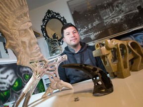 Shawn McClure poses with some of his carved stone and antler statues on February 3, 2015. Ryan Jackson/Postmedia Network