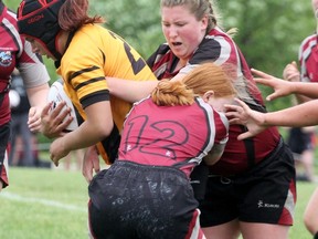 Northwestern’s Mia Dickson (12) and Mallory Petrie wrap up a Trenton High School player during the OFSAA A/AA girls rugby championships Monday in Stratford. Cory Smith/The Beacon Herald
