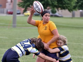 St. Mike’s Christena Downey makes a pass before getting tackled by two Notre Dame players during the OFSAA girls rugby championships Tuesday in Stratford. St. Mike’s won 41-7. Cory Smith/The Beacon Herald