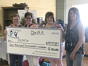Betty Landis, representing DEMSA, accepts a cheque from 100 Women Who Care Hanna founders Tannis Voltner, Laurie Armstrong and Kim Barth at their inaugural meeting on May 28 in Hanna, Alta.