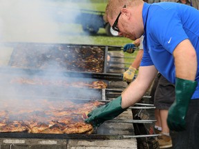 TIM MEEKS/THE INTELLIGENCER
Ron Urquhart, a volunteer from Shorelines Casino, checks the temperature of chicken during the 38th annual Kiwanis Chicken BBQ Wednesday at Quinte Curling Club.