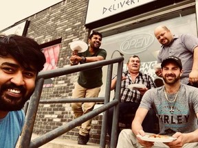FACEBOOK PHOTO
Co-owner George Abraham, Tittu Chandra Bose, who helped set up the restaurant, co-owner Jim Melahrinakis, co-onwer Rob Mackay (standing) and Steven Wallace take a picutre outside the newly opened Lil Ava’s Pizza.