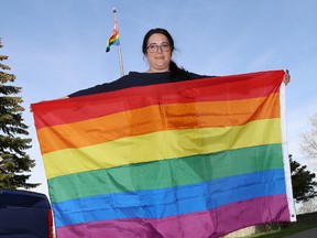 Michelle Levis, a teacher at Ecole secondaire Macdonald-Cartier, holds an LGBTQ flag outside the school on Wednesday. The LGBTQ flag has been raised at the high school to recognize Pride month. (John Lappa/Sudbury Star)