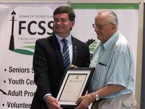 Minister Oneil Carlier presents an award to a local senior during the provincial launch of Seniors Week at Stony Plain’s Heritage Pavilion.