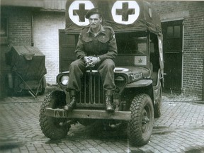 Ernie Wood sits on the hood of his WWII modified Jeep ambulance.
