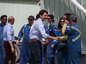 Prime Minister Justin Trudeau shakes hands with workers as he visits the Kinder Morgan terminal in Sherwood Park on June 5.
