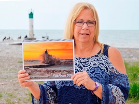 Shirley Goddeeris stands with a calendar commemorating Port Bruce, where a bridge collapsed earlier this year. She hopes it will help shine a positive light on the small lakeside town and will draw people to the area this summer. (Louis Pin/Times-Journal)
