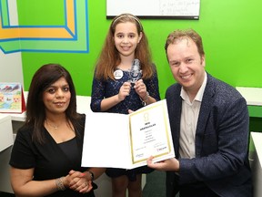 Meera Grover, director of Eye Level of Sudbury, and Sudbury MP Paul Lefebvre present nine-year-old Daniela Grottoli with a trophy, cheque and certificate in Sudbury. Daniela is the silver prize winner in the Eye Level North America speech contest. Daniela is donating her winnings in memory of goalie Parker Tobin of the Humboldt Broncos. John Lappa/Sudbury Star/Postmedia Network