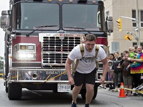 Matthew Fast of Cobourg pulls a fire truck 100 metres along Dalhousie Street in downtown Brantford on Saturday as part of the 10th anniversary celebrations of Harmony Square. Fast's father, Kevin, a Brantford native and Guinness World Record holder, also demonstrated his ability to pull a fire truck. 
Brian Thompson/The Expositor