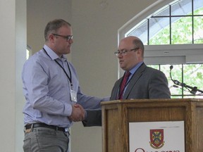 Dan Hendry receives the Sustainability Champion award from Sustainable Kingston chair Matt Benson. (Brigid Goulem/For The Whig-Standard)