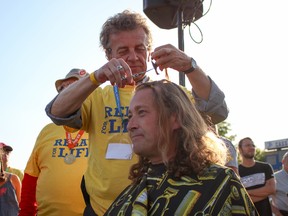 Relay for Life community champion Brian Donlevy gets the honours of cutting the first lock of Woodstock Mayor Trevor Birtch's hair at the Relay for Life in Woodstock on June 8. (Chris Funston/Sentinel-Review)