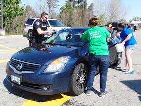 Photo by Helen Morley/For The Mid-North Monitor
Constable Ed Stortz, Joelle Poirier and Rhonda Hollywood washing windows for Tim Hortons Camp Day
