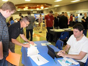 Ryan Sorenson 20, left, registers for a job fair held in Tilbury, Ont. on Monday June 11, 2018 with the help of Kim Cooper, middle and Spencer Pray, with Chatham-Kent's Economic Development Services, which organized the event. Ellwood Shreve/Chatham Daily News/Postmedia Network