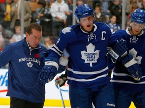 Former Toronto Maple Leafs head athletic therapist Andy Playter helps to carry captain Dion Phaneuf off the ice with the help of defenceman Carl Gunnarsson in this 2010 file photo from Playter's tenure with the Leafs. The Attack hired Playter to serve in the role of head strength and conditioning coach following the departure of Andrew Hopf. File photo/Postmedia.