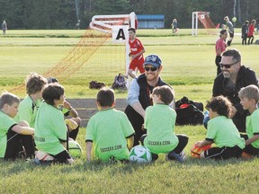 Coaches Cory Coulter and Mike Nadeau give a pre-game pep talk to their Green Apple Realty team, which plays within the boys under-8 division of the Sault Youth Soccer League. The summer soccer season began in Sault Ste. Marie last week.