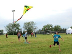 Alec Lachance, 10, of Chatham flies a kite owned by his mother Karine, back left, since age 10, during the Wheatley WindFest, held on June 9. Also pictured is Alec's dad, Simon Lachance. Ellwood Shreve/Postmedia Network