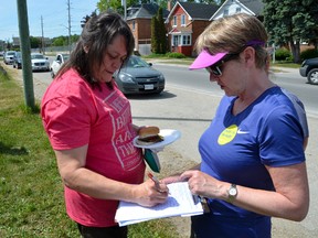 Janet Gibson of Owen Sound signs a petition supporting the 30 OPSEU nurses, clerical and custodial staff of the Owen Sound Family Health Organization, as Gail Potter tells her about the strike. A union rally and barbecue was held to boost spirits and thank the community for its support on Tuesday. (Scott Dunn/The Sun Times)