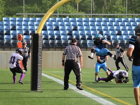 The Fort McMurray Monarchs offence leaps over the Calgary Wolfpack defence to score a touchdown. Laura Beamish/Fort McMurray Today/Postmedia Network