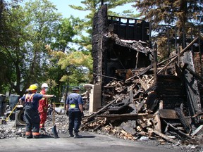 Chesley and Area Fire Department members and an official with the Office of the Fire Marshal investigate the scene of a fatal house fire in Chesley on Tuesday. Three people died in the blaze, which happened early Monday morning. (Derek Lester Postmedia Network)