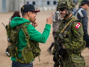 A member of Exercise Maple Resolve 2018 chats with a villager at Ashigli Village in Wainwright, AB on May 14. Soldiers took part in a crowd control scenario. The soldiers participating in this scenario interacted with civilian actors to put their training into practice.