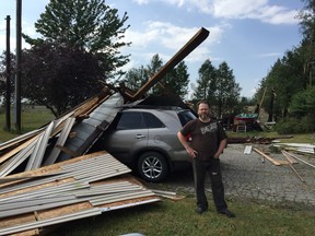 A late afternoon storm caused heavy damage to several properties in the Waterford area on Wednesday. Pictured, Darryl Fox stands alongside his sister Marcy's car, which was covered by a garage during the storm.
KIM NOVAK/SIMCOE REFORMER