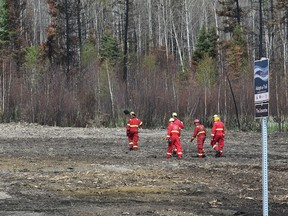 A crew of firefighters from Calgary look for hot spots along a fire guard behind homes in the north end of Timberlea on June 2, 2016. The fire guard was carved out of a trail system shortly after the May 3, 2016 wildfire. Ed Kaiser/Postmedia Network