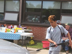 Zavier Gammie sprays off car June 4 during a car wash fundraiser at J.T. Foster High School to raise money to renovate the gymnasium change rooms. Ian Gustafson Nanton News