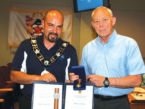 Photo by DAVID BRIGGS/FOR THE STANDARD
Tom Turner receives The Sovereigns Medal for Volunteers from Elliot Lake Mayor Dan Marchisella at Monday’s council meeting.