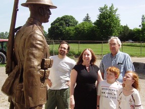 Leanna Simpson admires the bronze soldier from the city's Great War Memorial, with children Jack and Ella Judson. Simpson funded restoration of the statue. They are joined by Tyler Fauvelle, left, the Sudbury sculptor who did the work, and Herb Warren, rear, chair of the Veterans Memorial Garden project. (Eric Bunnell/Times-Journal)