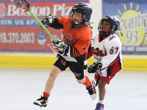 Vandolders Home Team's Nathan Laycock, left, jumps to catch the ball while being chased down by his opponent Welland Redbirds' C. Stewart during their opening tyke division game in the Owen Sound Minor Lacrosse Fathers Day Heritage Classic at the Julie McArthur Regional Recreation Centre  on Friday June 19, 2015 in Owen Sound, Ont. James Masters/Owen Sound Sun Times/Postmedia Network