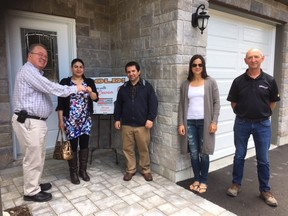 Real estate agent Mike Cowan hands the keys to Sharifa and Naser Mohammed Yar after the couple purchased the latest HomeBuild for Healthcare home Thursday in Trenton. With them were Sarah McDonald of McDonald Homes and Gerald Draaistra of Vanderlaan Building Products and the Trenton Memorial Hospital Foundation.