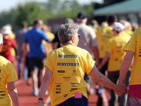 Cancer survivors Judy and Bob Worley hold hands while walking the Belleville Relay for Life's survivors' lap with friend Sandy Pamenter Saturday evening at Mary-Anne Sills Park. Pamenter and Judy Worley run a cancer-related support group.
