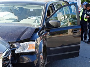 Belleville Police Const. Joshua Woodcock conducts an interview following a three-vehicle collision at about 6 p.m. Saturday in the intersection of Pinnacle Street and Bridge Street East in Belleville. No injuries resulted but there was significant damage to a Dodge Grand Caravan, right, Toyota Yaris, background, and GMC Terrain, left. Police charged one driver with failing to obey a red light, but said only that it was the driver of a vehicle southbound on Pinnacle and did not specify the model.