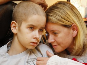 Aidan Reil, 11, watches TV with his mother, Sarah Grover, and father, Wayne Reil, close by at home in Trenton. Both parents have taken time away from work to care for Aidan since his terminal diagnosis in mid-May. Yet Aidan is scheduled to undergo more chemotherapy and a walk to raise funds for the family will be held Wednesday, June 20 at 6:30 p.m. at the Lions Club pavilion in West Zwicks Centennial Park.