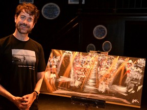 Legally blind painter, Bruce Horak, poses with the audience portrait he painted while telling the stories of his life and the death of Tom Thomson at the Studio Theatre in Stratford Sunday morning. (Galen Simmons/The Beacon Herald/Postmedia Network)