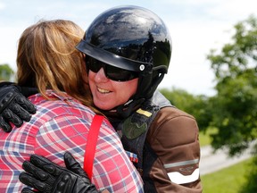 Motorcyclist Robert O'Hara of Sydenham, Ont. hugs Angela Roddy of Hillier before the third-annual Darren Williams and Wayne Boone Memorial Ride Saturday in Hillier. A car struck riders of the 1 Canadian Army Veterans motorcycle group in 2015, killing Williams and Boone and injuring O'Hara badly. Roddy and her husband, Chris, ran from their nearby home to help.