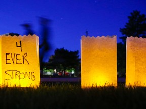 Participants in the 2018 Relay for Life in Belleville walk past luminary candles dedicated to people fighting cancer or who have died from it.