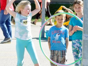 Selina Gethke (left) raises her arms in victory while successfully tossing a bean bag through the hoop, or the cartoon figure’s mouth, during the annual Fun Fair held at Upper Thames Elementary School (UTES) last Thursday, June 14. ANDY BADER/MITCHELL ADVOCATE