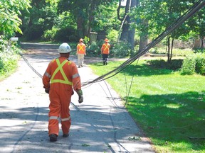 Hydro workers inspect downed wires along Hill Road in Port Stanley a day after heavy storms wreaked havoc in the lakeside town. One resident on Hill Street said she had "never seen anything like it" in the 25 years she's lived there. (Louis Pin/Times-Journal)